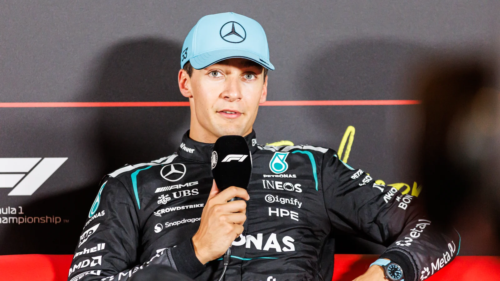 George Russell în combinezonul Mercedes, cu microfonul în mână, la Zandvoort în 2026